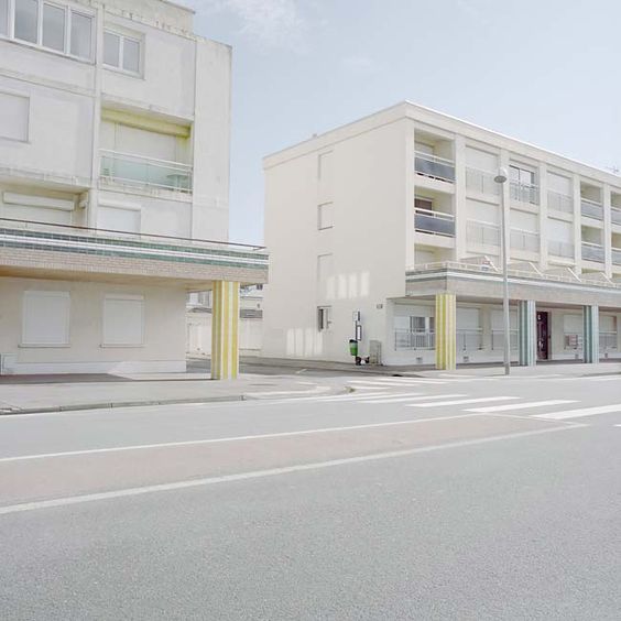 an empty street in front of a white building