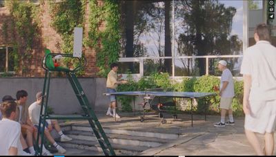 a group of people playing a game of ping pong