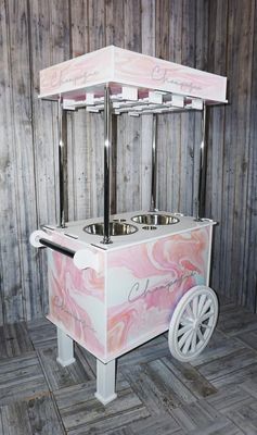 a pink and white ice cream cart on a wooden floor