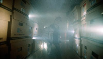 a man standing in a room filled with boxes