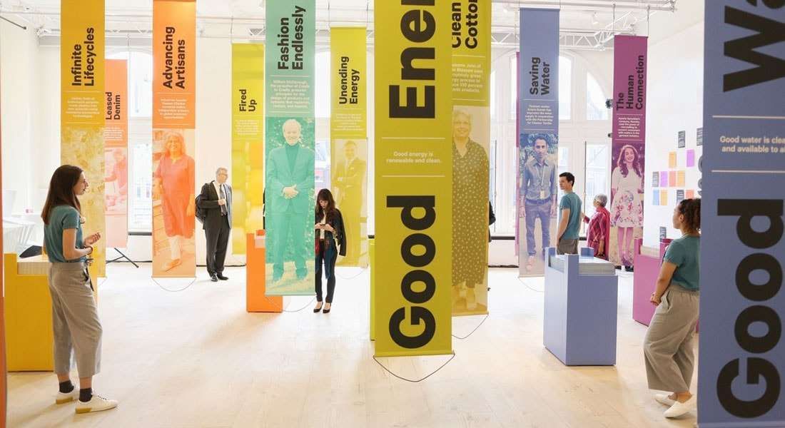 a group of people standing in a room next to colorful banners