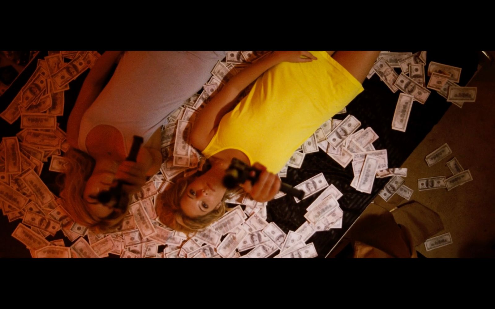 a woman laying on top of a bed covered in money