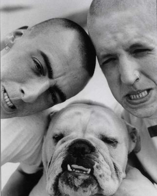 two men and a dog pose for a picture