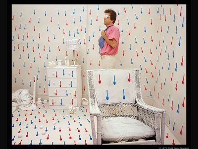 a man standing next to a white chair in a room