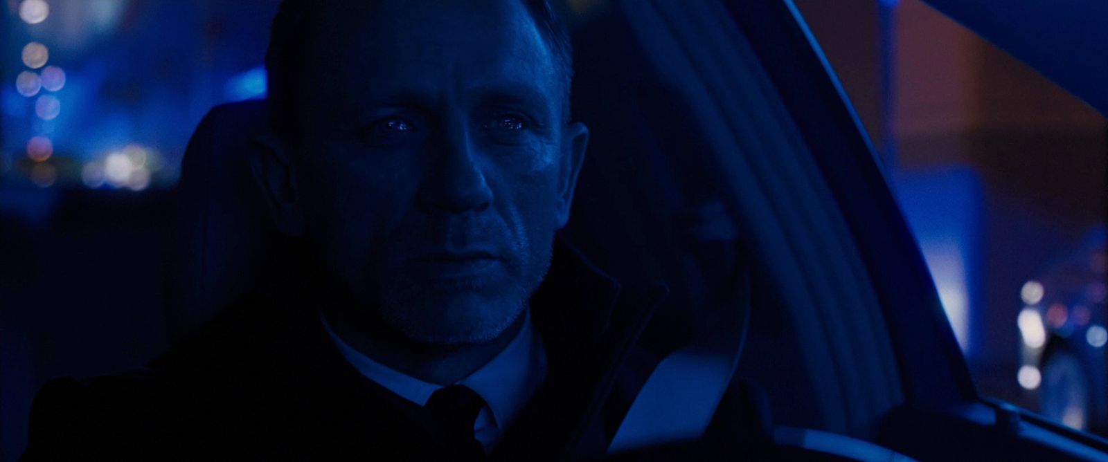 a man in a suit and tie sitting in a car