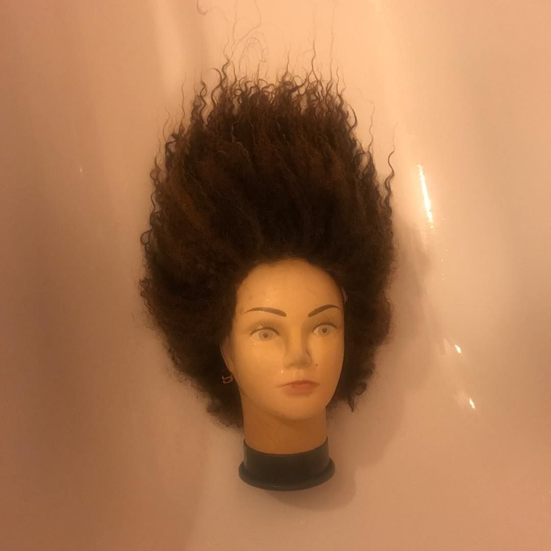 a mannequin's head with a wig on top of it