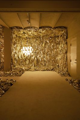 a room that has a gold curtain on the wall