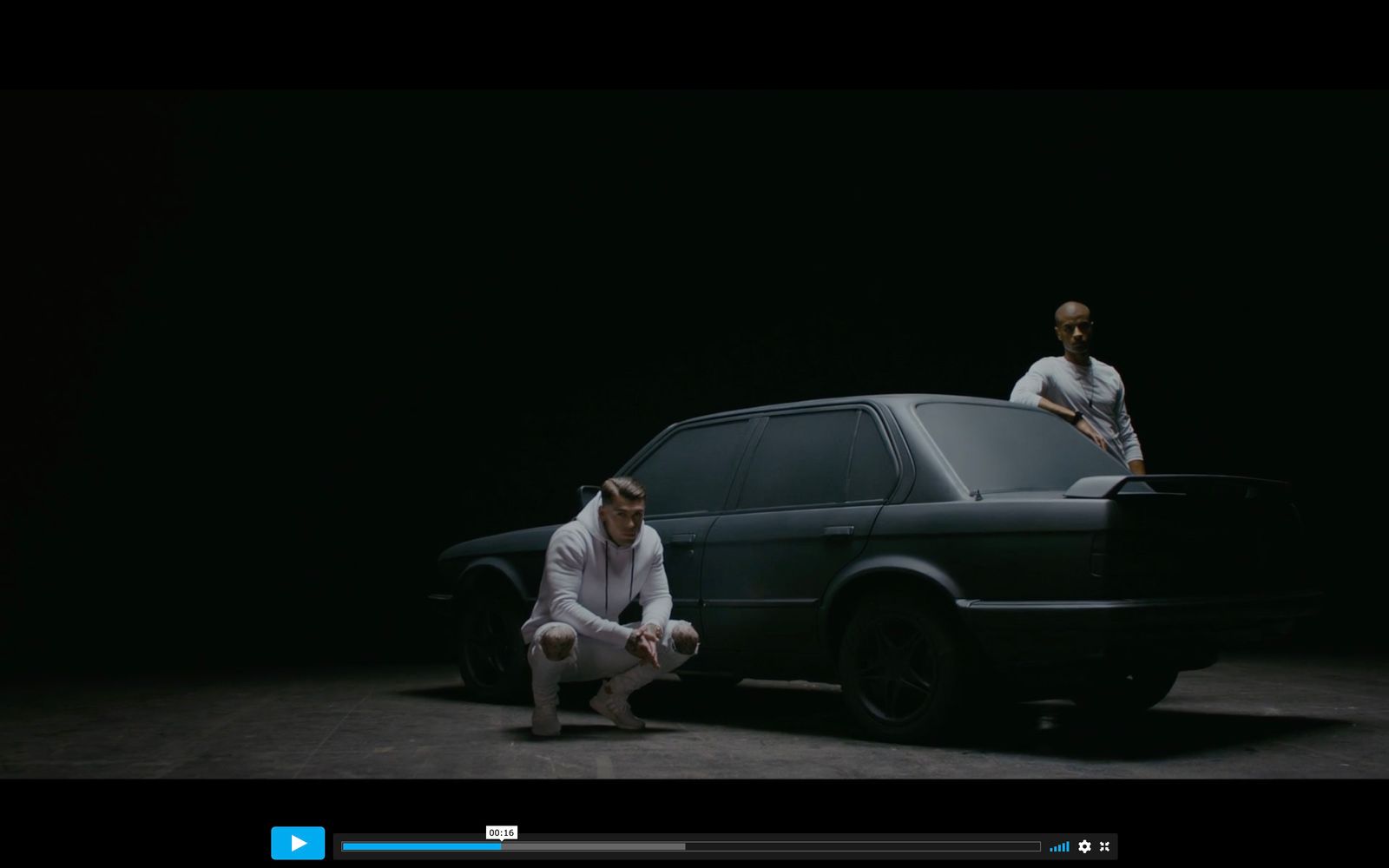 two people standing next to a car in the dark