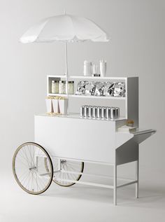 a white cart with a white umbrella on top of it