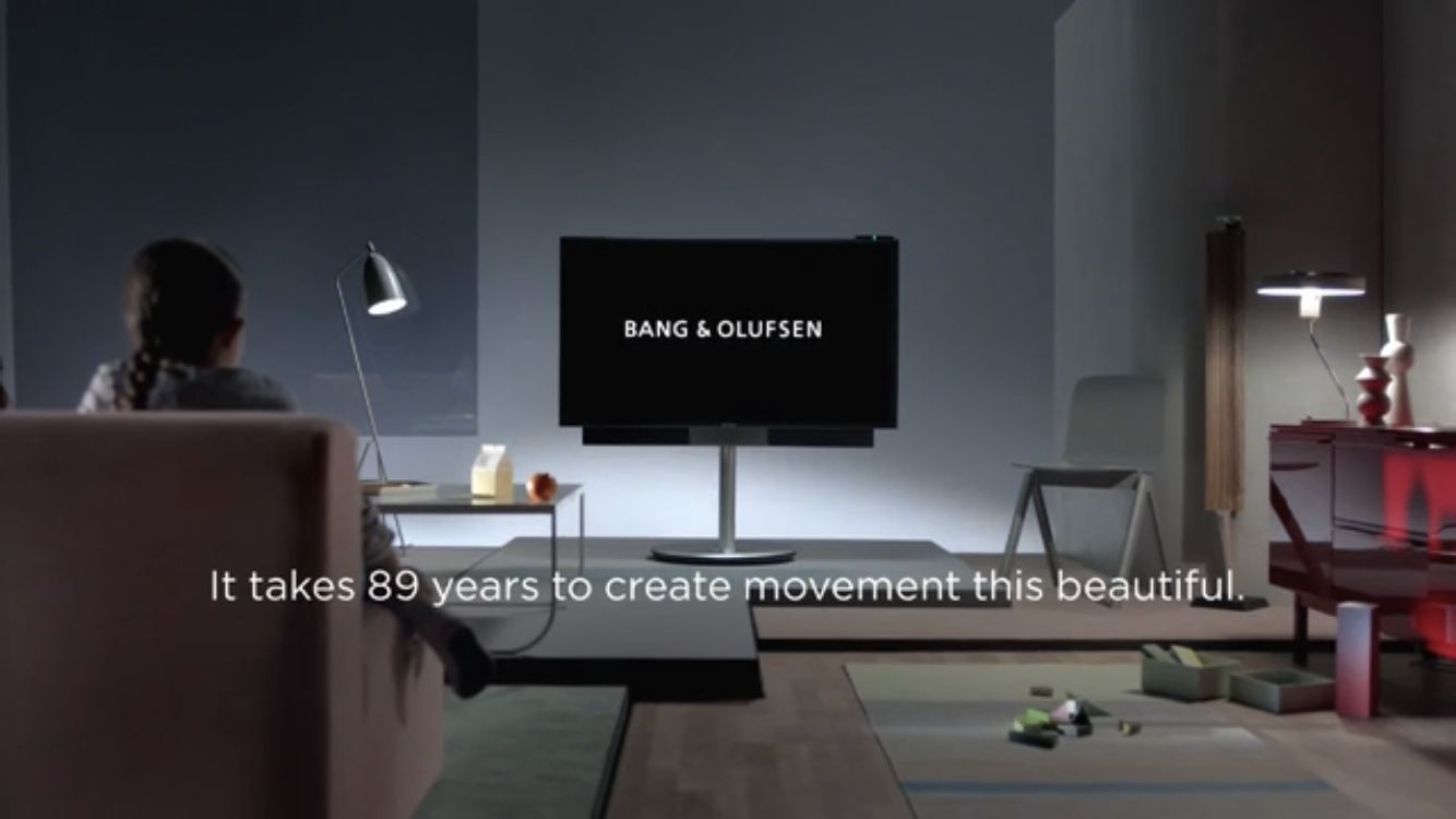 a woman sitting on a couch in front of a flat screen tv