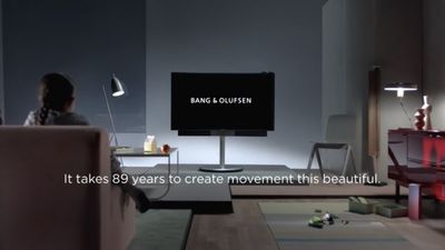 a woman sitting on a couch in front of a flat screen tv