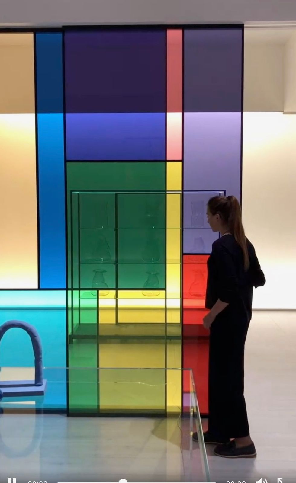 a woman standing in front of a colorful wall