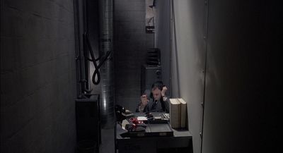 two people sitting at a table in a dark room