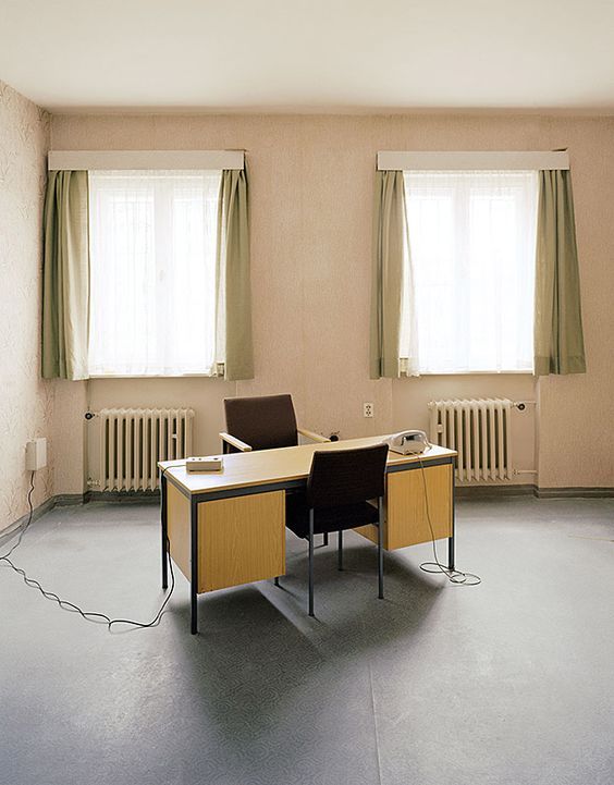 a room with two desks and two windows