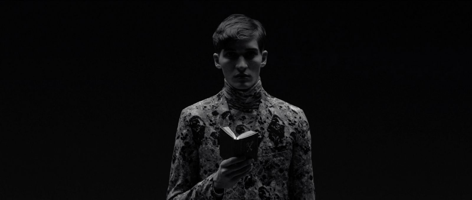 a man in a black and white photo holding a book