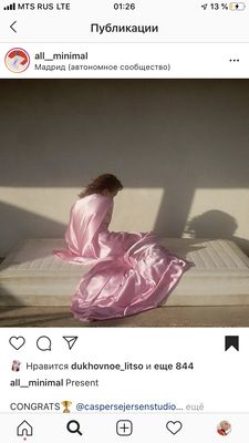 a woman in a pink dress sitting on a mattress