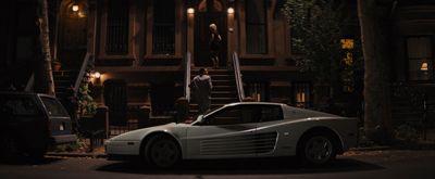 a white sports car parked in front of a house