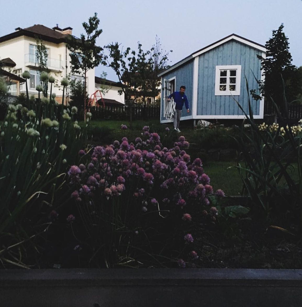 a man standing outside of a blue house