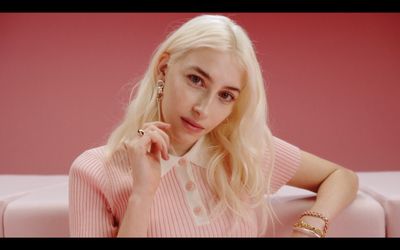 a blonde woman sitting on a pink couch