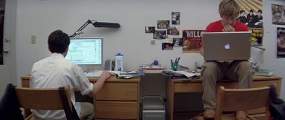 a man sitting at a desk with a laptop computer