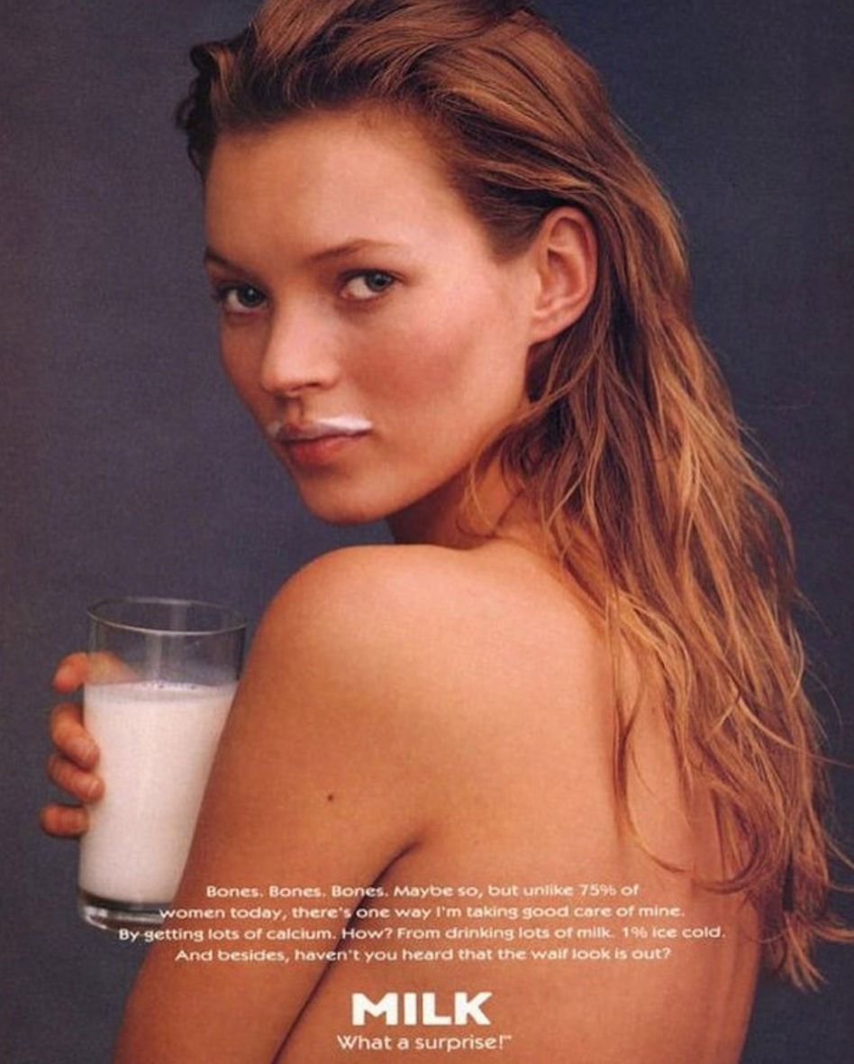 a woman is holding a glass of milk