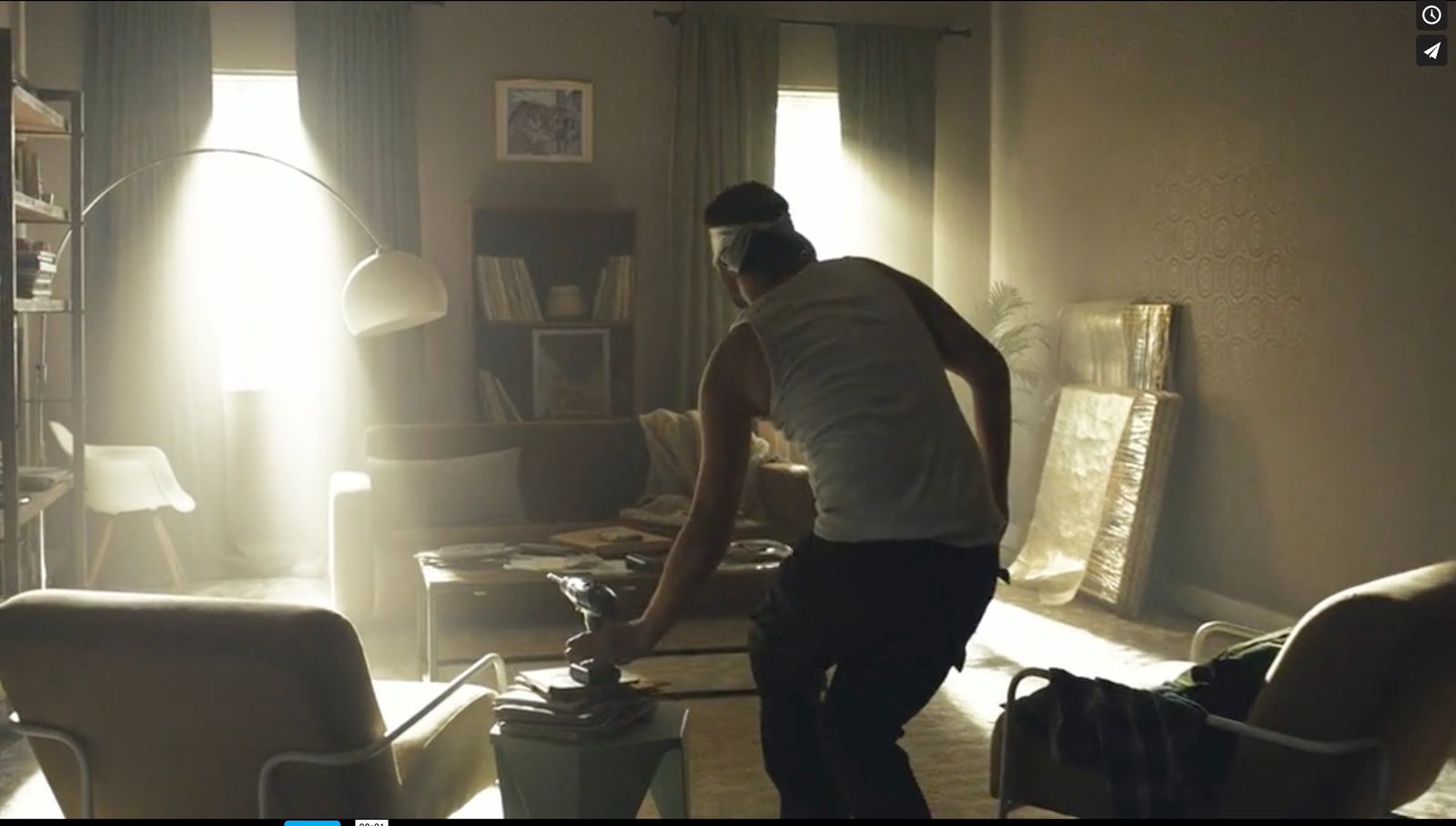 a man standing in a living room with a vacuum