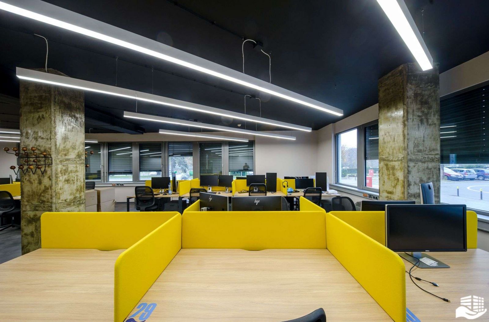 an office with yellow and black furniture and a large window