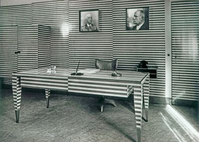 a black and white photo of a desk in a room