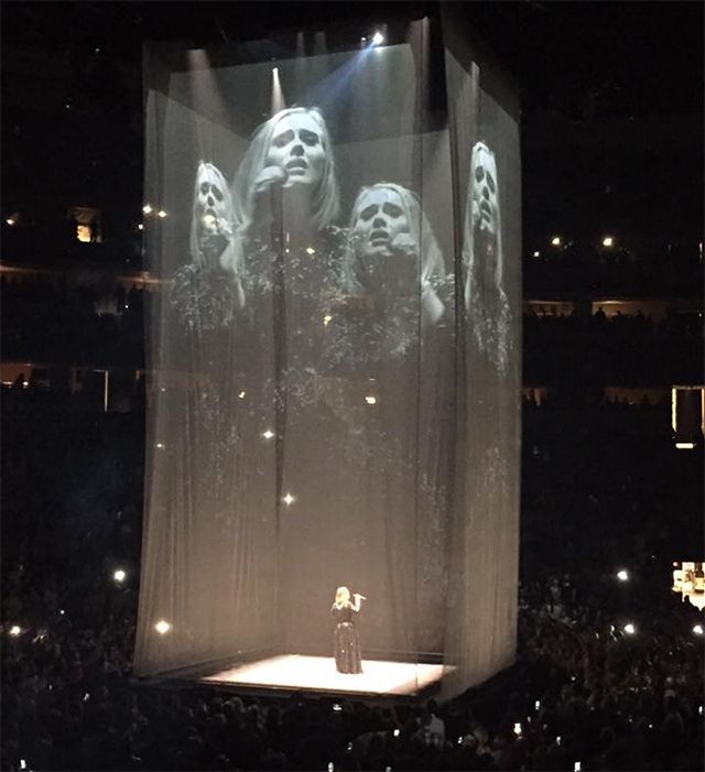 a woman standing on a stage in front of a crowd