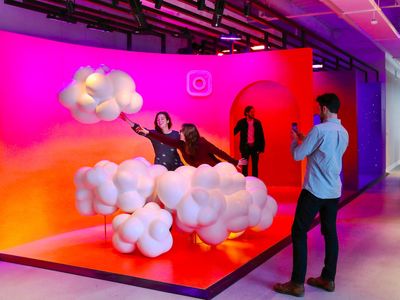 a group of people standing around a display of balloons