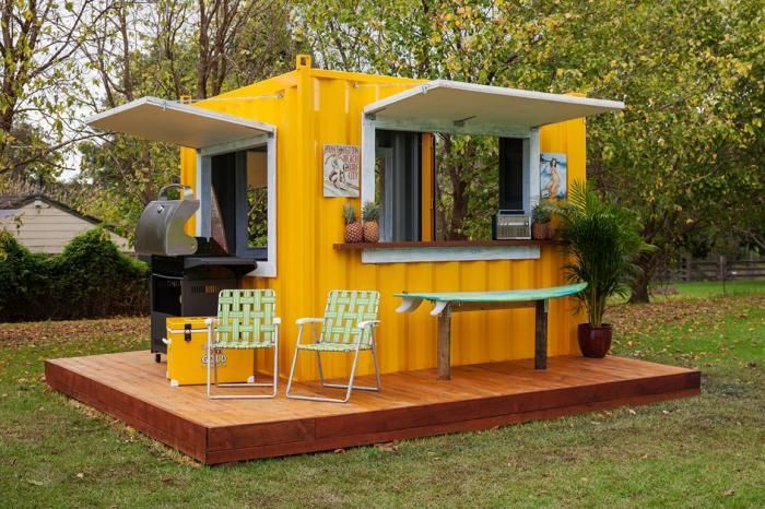 a small yellow house with a table and chairs