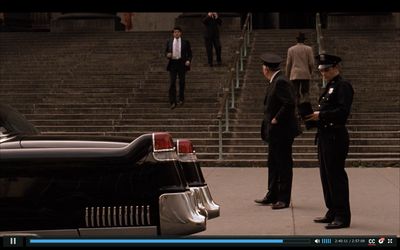 a couple of men standing next to a black car