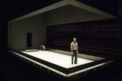 two men standing on a stage in the dark