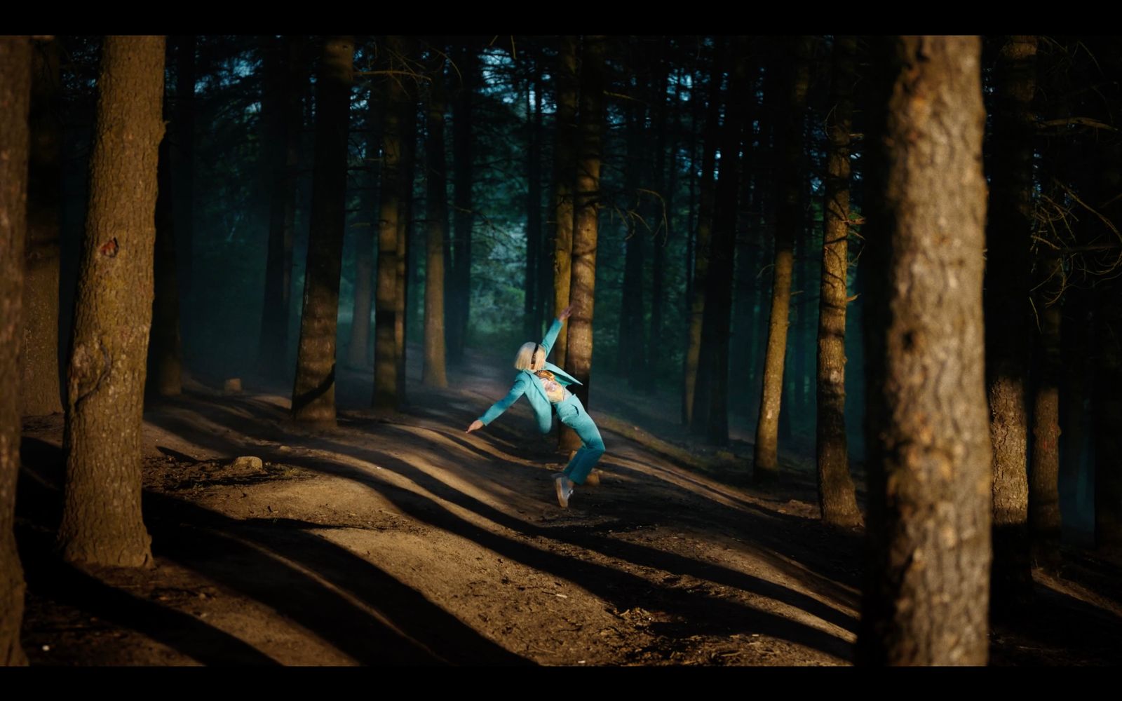 a person jumping in the air in the middle of a forest