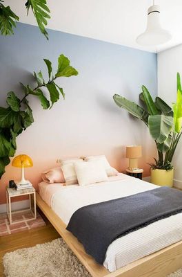 a bedroom with a bed and a plant on the wall