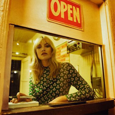 a woman sitting at a counter in front of a window