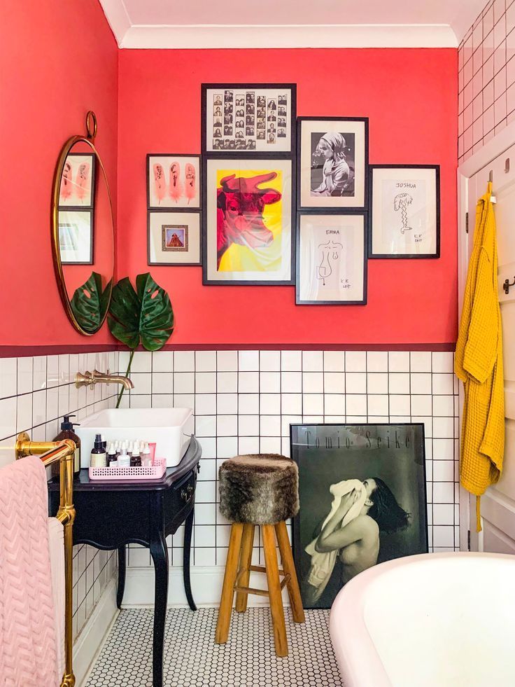 a bathroom with pink walls and pictures on the wall