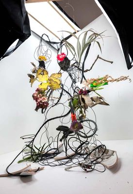 a sculpture made of wires and flowers on a table