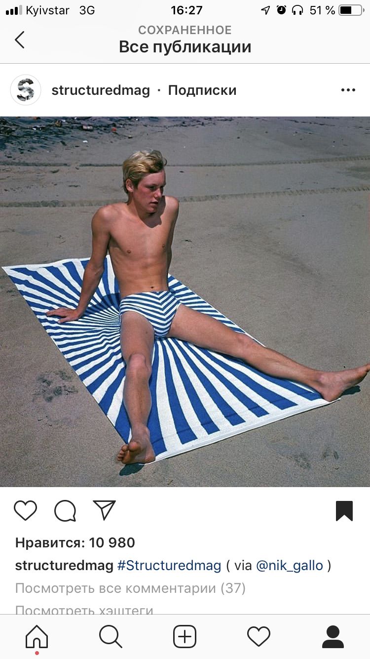 a man sitting on top of a blue and white striped towel