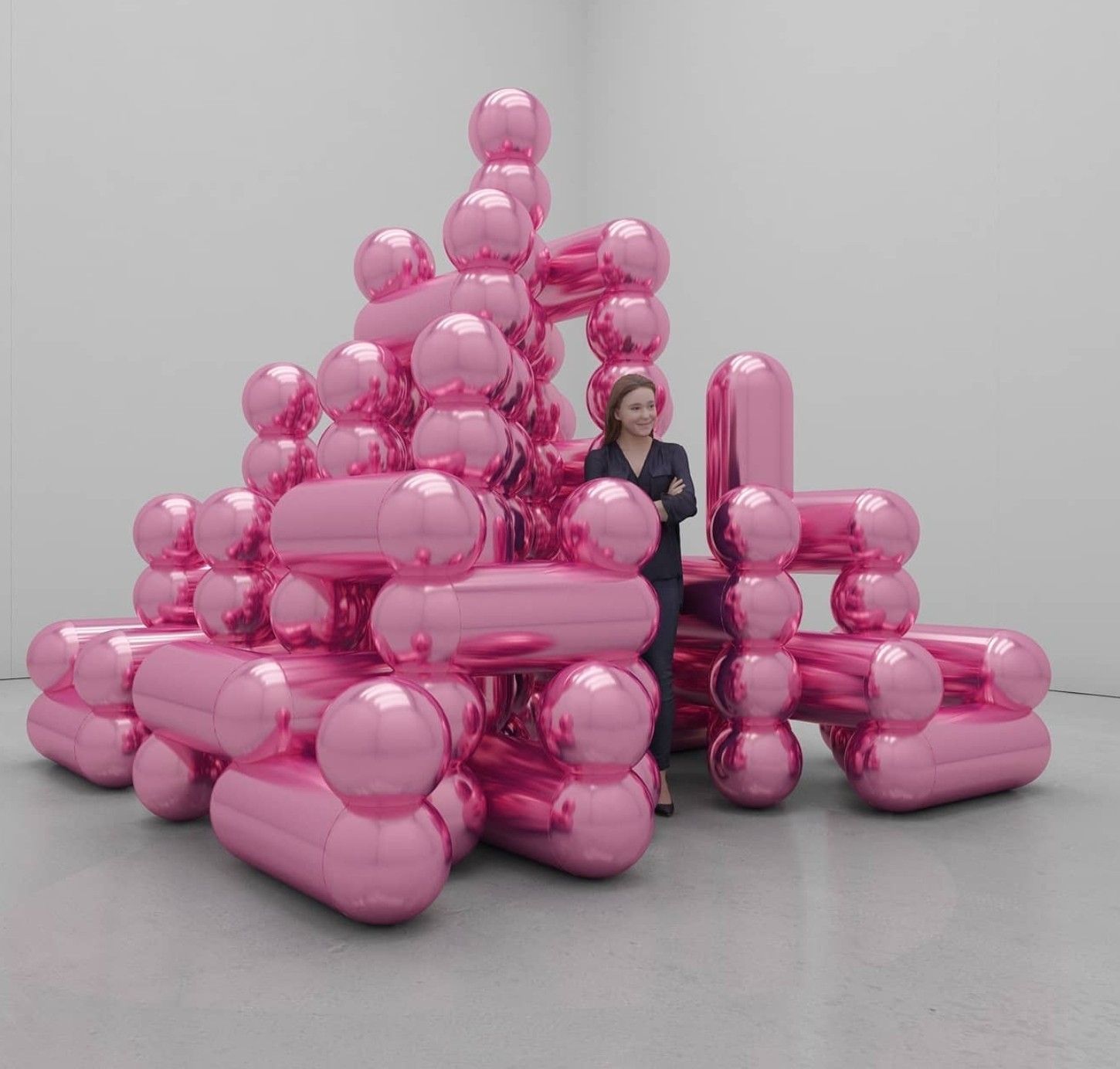 a woman standing in front of a pile of pink balloons