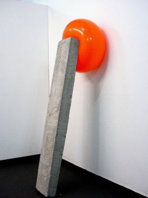 an orange object sticking out of a white wall