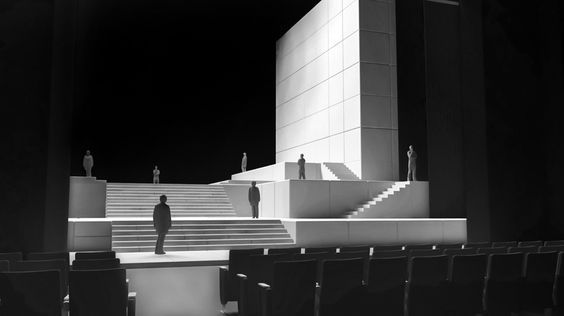 a black and white photo of a man standing in front of a building