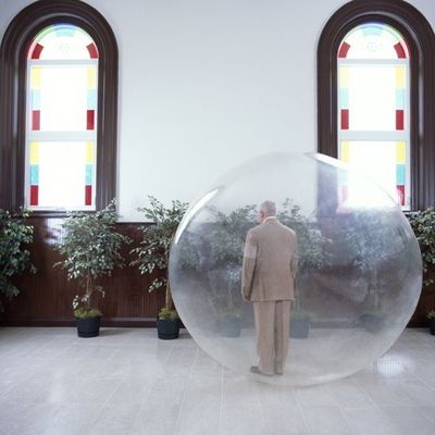 a man in a suit standing inside of a large bubble