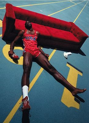 a man laying on a basketball court next to a couch