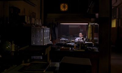 a man sitting at a desk in a dark room