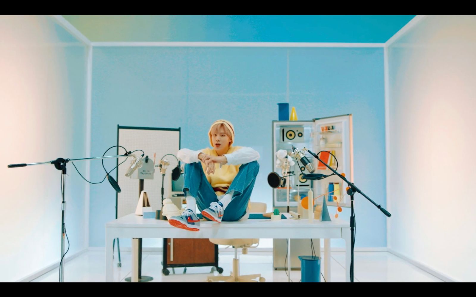 a woman sitting on top of a table in front of a microphone