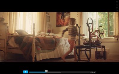 a young girl running across a bed in a bedroom