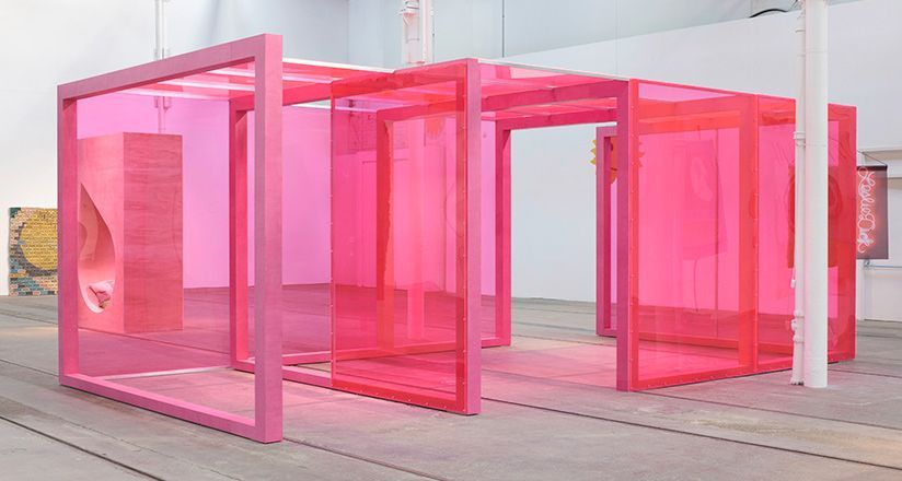 a group of pink stalls sitting on top of a wooden floor