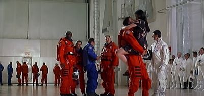 a group of people in red jumpsuits standing in front of a group of