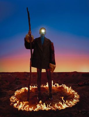 a man standing in a circle of fire holding a gun